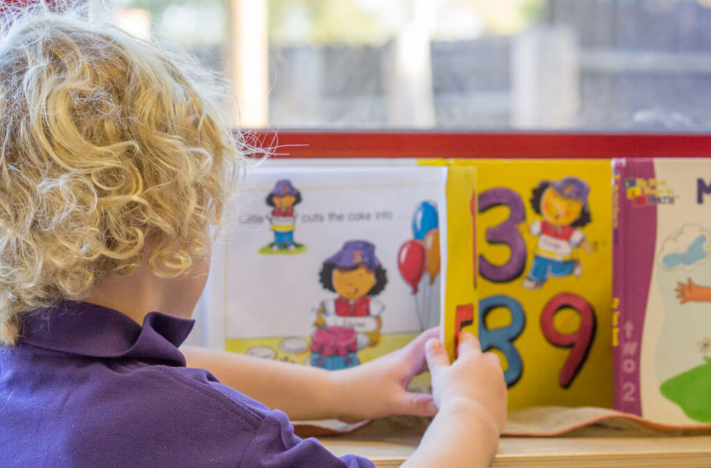 Nursery child reading a book