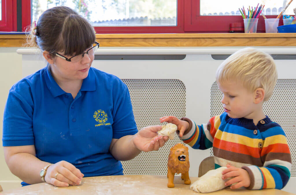 Child playing with nursery staff