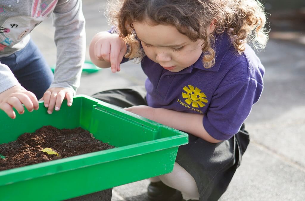 Child playing outdoors with mud