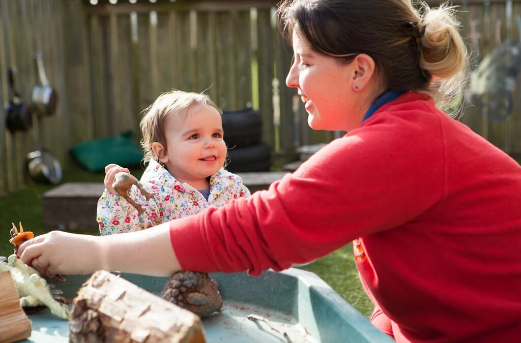 Child playing with nursery team